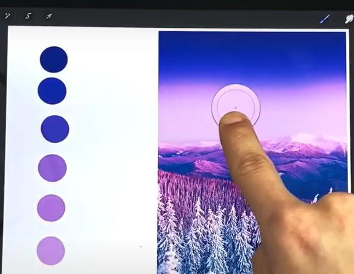 Someone holding down their finger on a photo in Procreate to select a color with color swatches